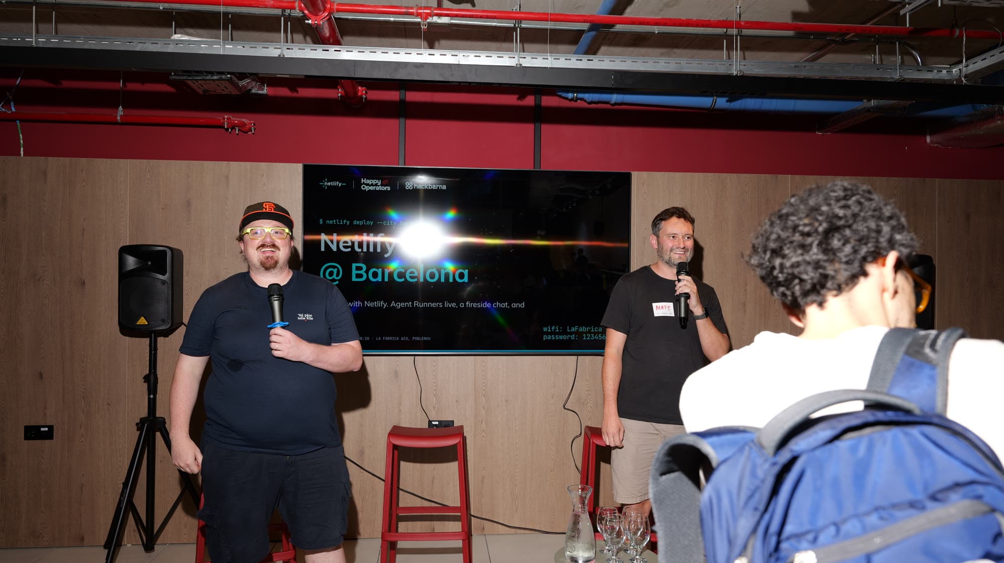 Two hosts welcoming attendees to Netlify Barcelona